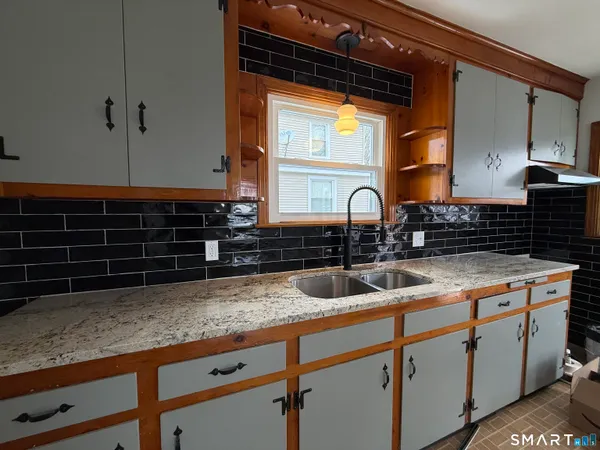 a kitchen with granite countertop a sink and a stove