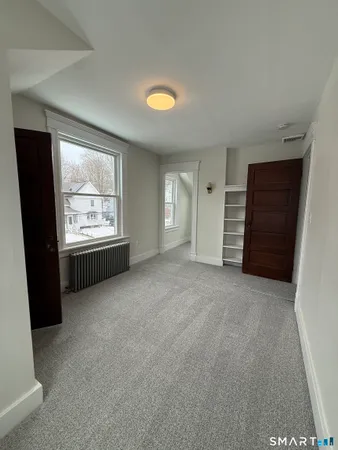 an empty room with a window and closet