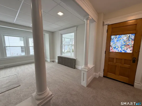 an empty room with windows cabinet and front door
