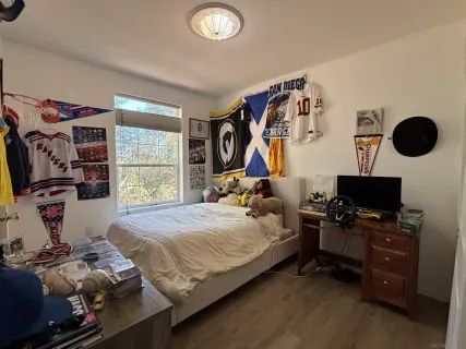 a bedroom with a bed and a flat tv screen on the dresser