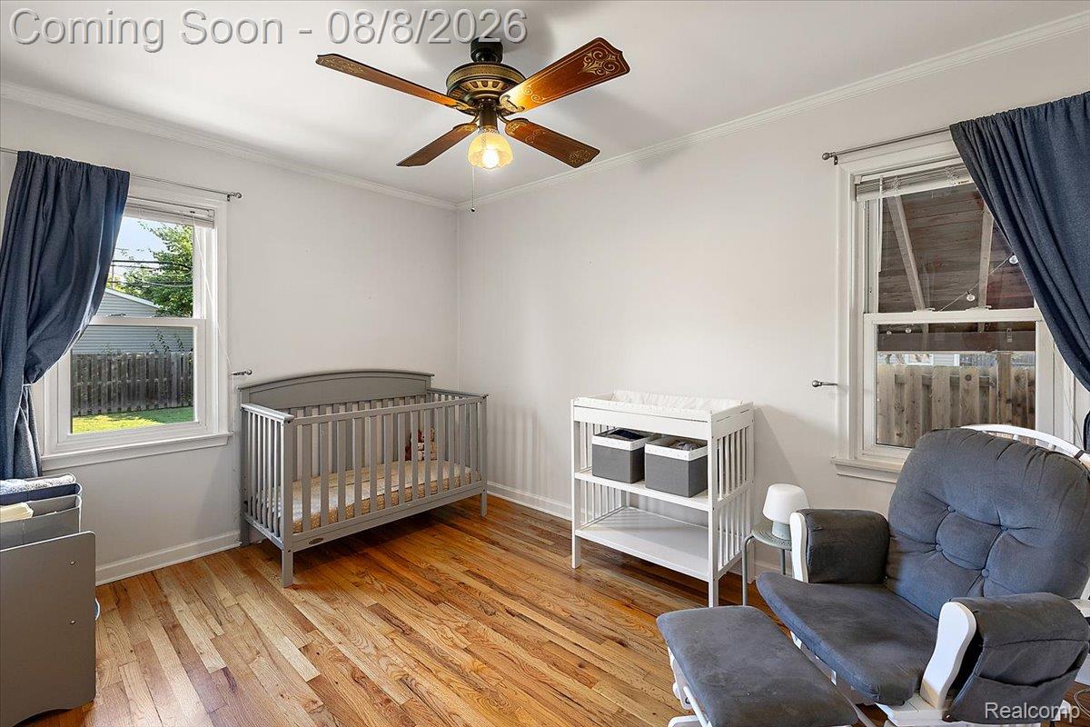 1150 West Eleven Mile Road Berkley, MI 48072 - Photo 11 of 29 Room featuring wood-finish flooring, white walls, and a ceiling fan with light fixture