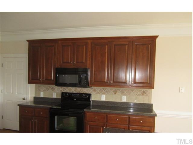 95 Steve Ridge Willow Spring, NC 27592 - Photo 6 of 10 a kitchen with granite countertop wood cabinets and black stainless steel appliances