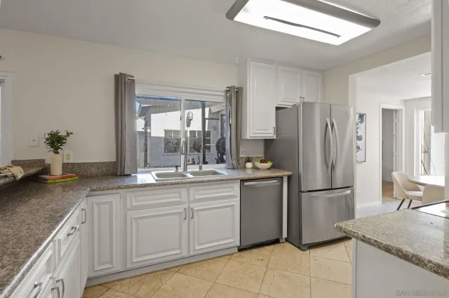 a kitchen with stainless steel appliances granite countertop a refrigerator and a sink