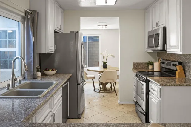 a kitchen with stainless steel appliances granite countertop a sink a stove and a refrigerator