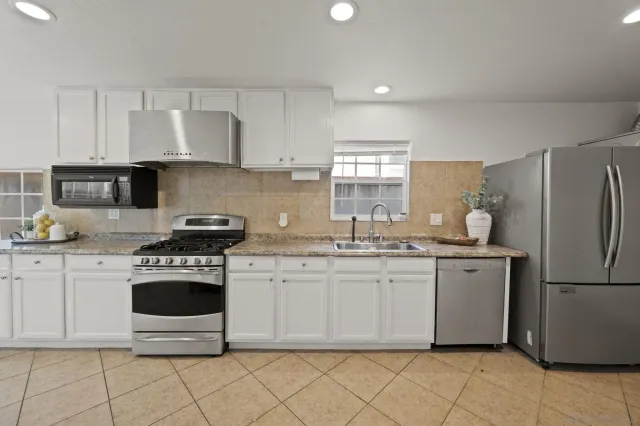 a kitchen with white cabinets and white appliances