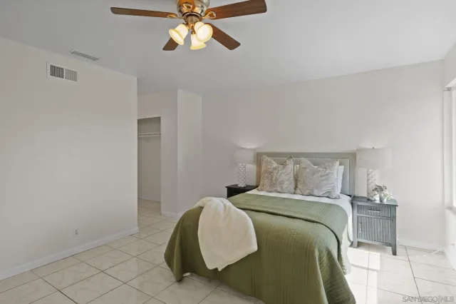 a bedroom with a bed and painting on the wall