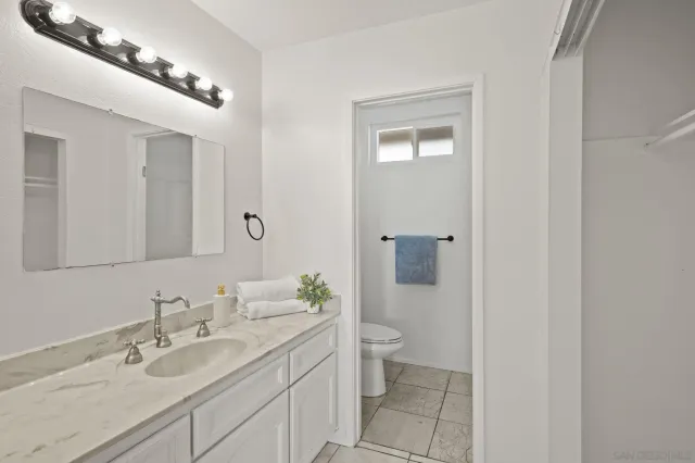 a bathroom with a toilet a sink and mirror