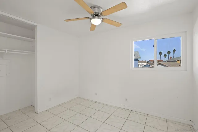 an empty room with closet and ceiling fan
