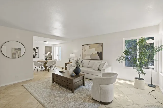 a living room with furniture a table and a potted plant