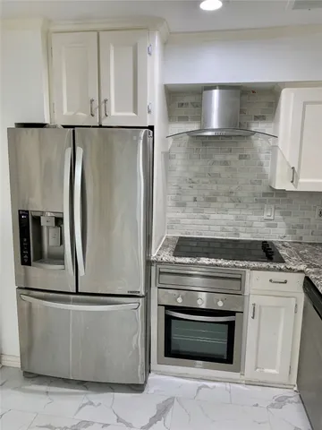 a metallic refrigerator freezer sitting inside of a kitchen