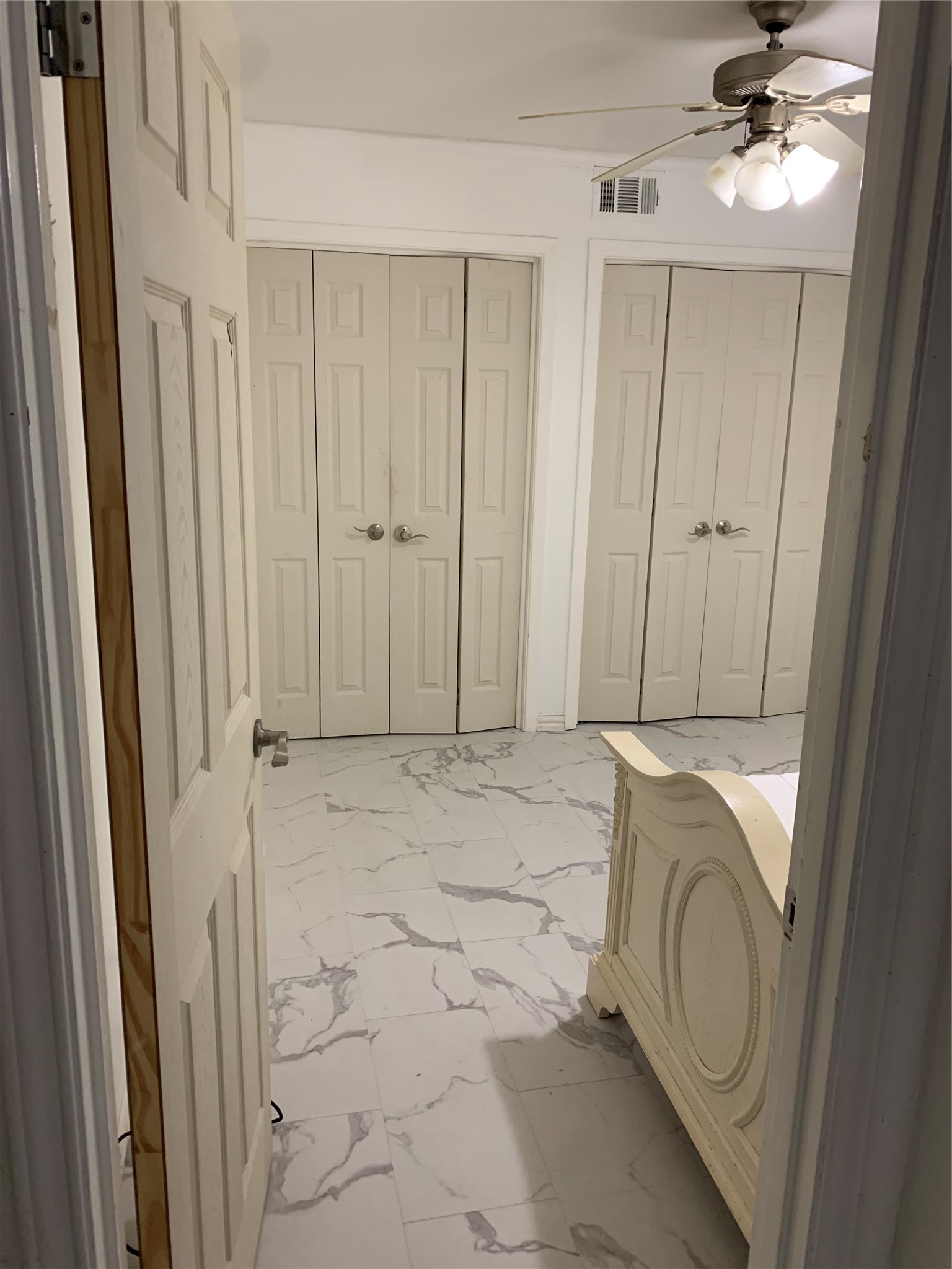 909 Silber Road, Unit 57J Houston, TX 77024 - Photo 6 of 14 Spacious closets offering ample storage space, complemented by elegant marble-style flooring and a modern ceiling fan for added comfort.