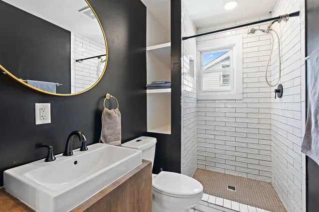 a bathroom with a sink a toilet and shower