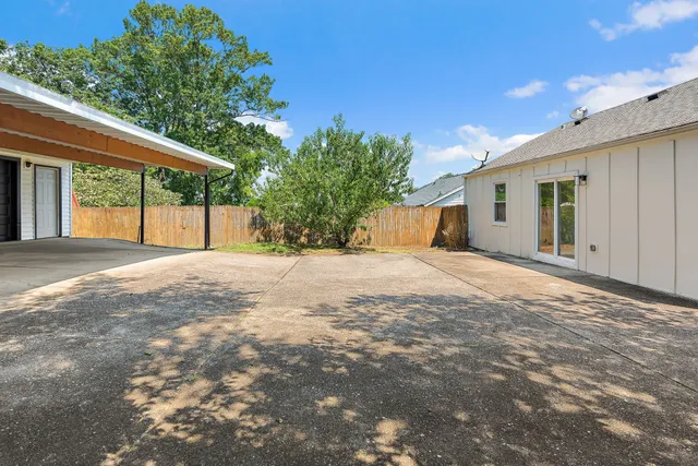 a view of a house with a yard and tree