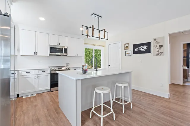 a kitchen with white cabinets and stainless steel appliances