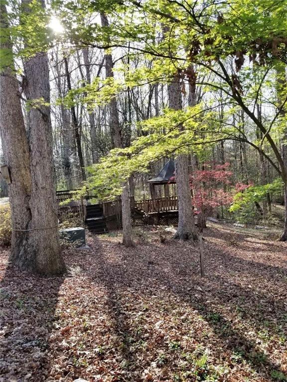 771 Lord Road Commerce, GA 30530 - Photo 14 of 16 a backyard of a house with large trees and wooden fence