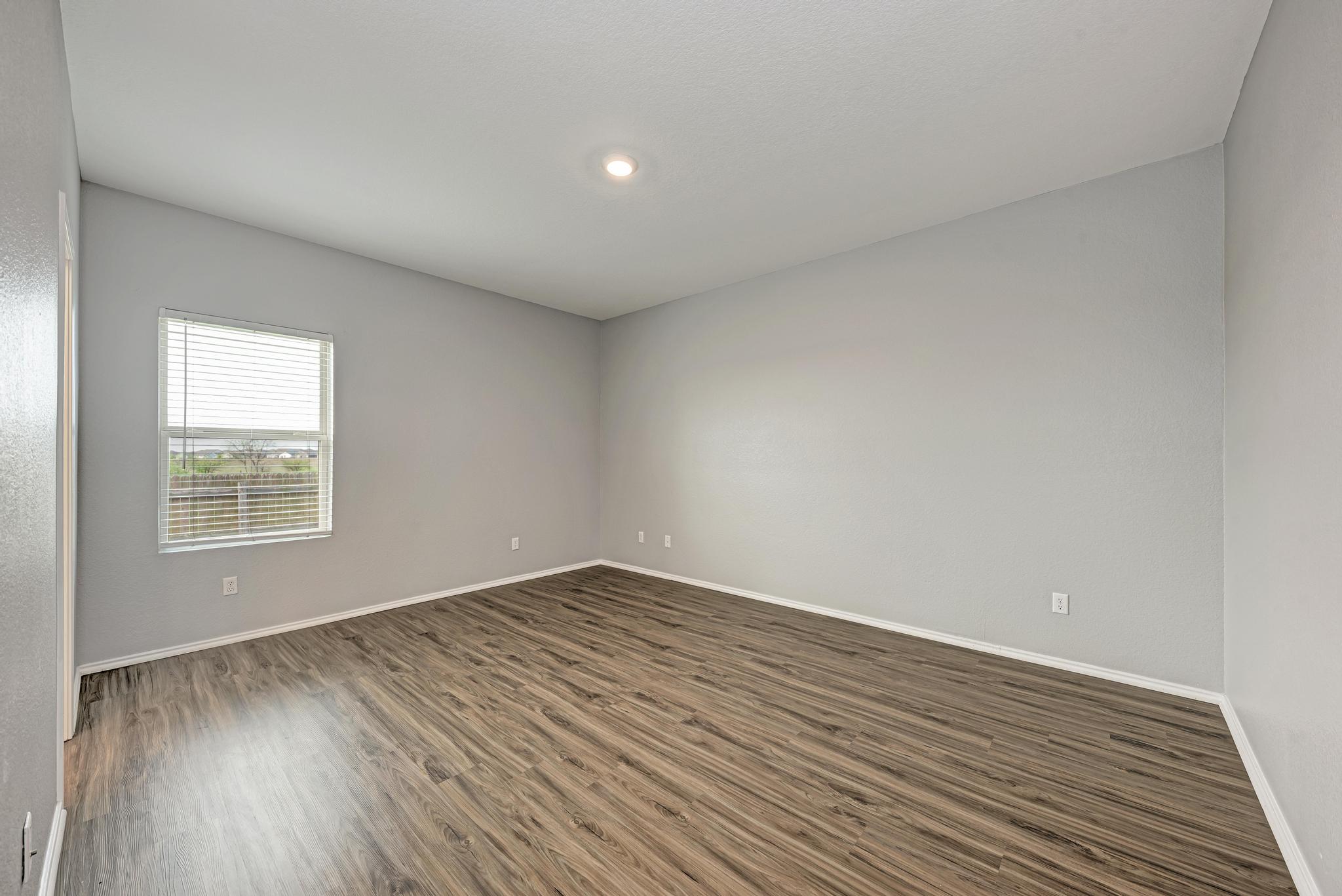 129 Vulcan Drive Jarrell, TX 76537 - Photo 18 of 35 an empty room with wooden floor and windows
