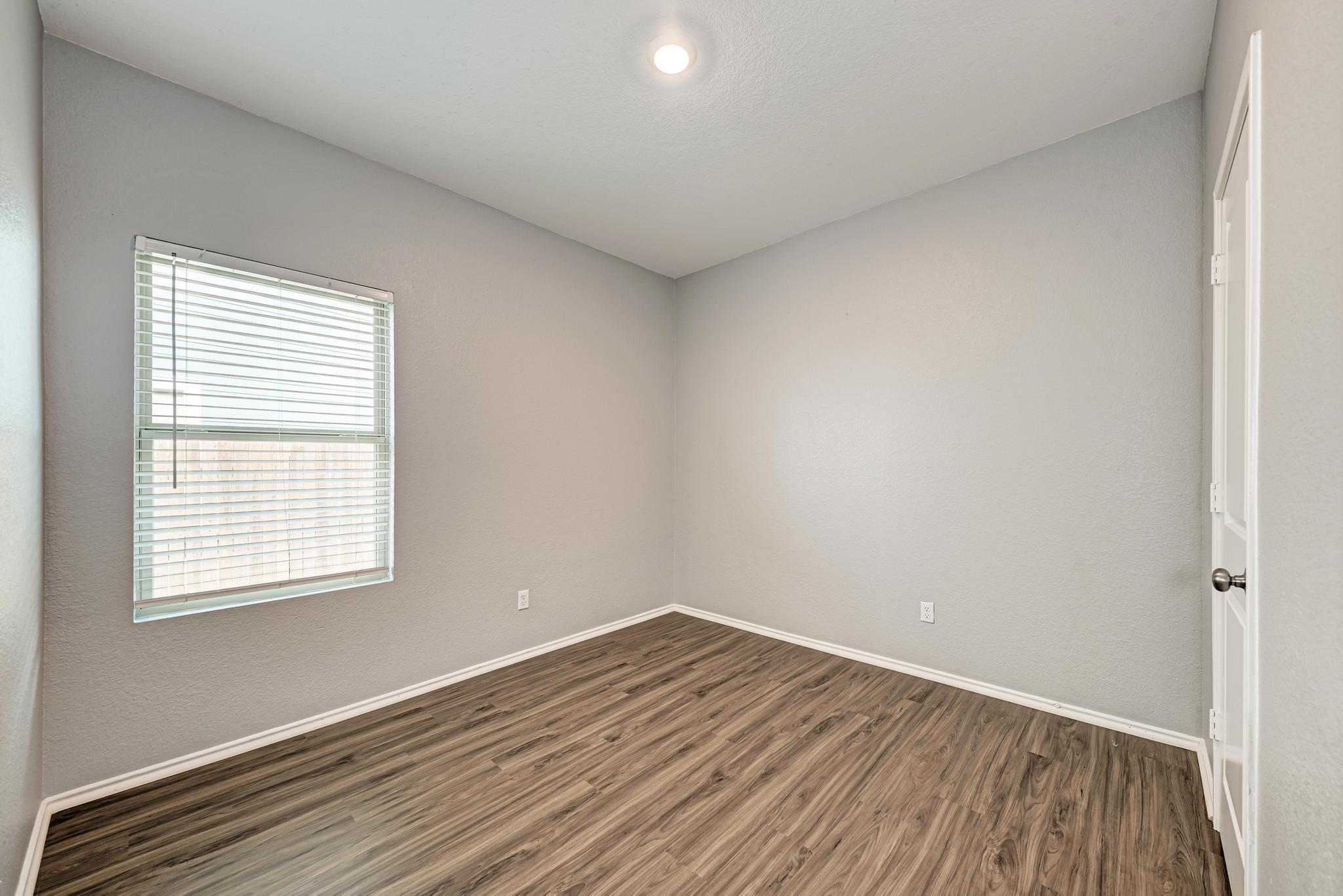129 Vulcan Drive Jarrell, TX 76537 - Photo 23 of 35 an empty room with wooden floor and windows