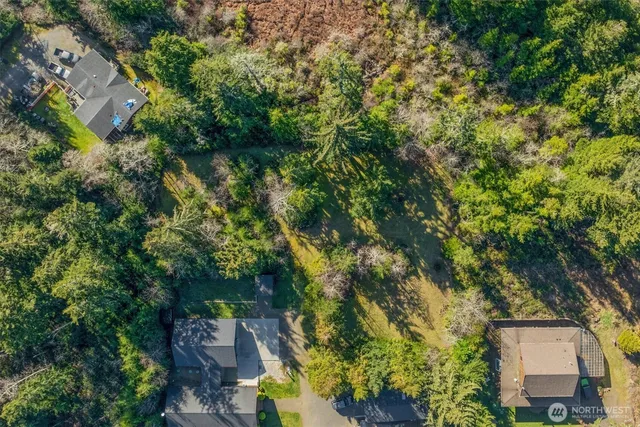 an aerial view of residential house with outdoor space and trees all around