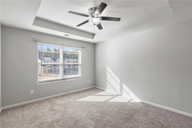 an empty room with a window and a fan