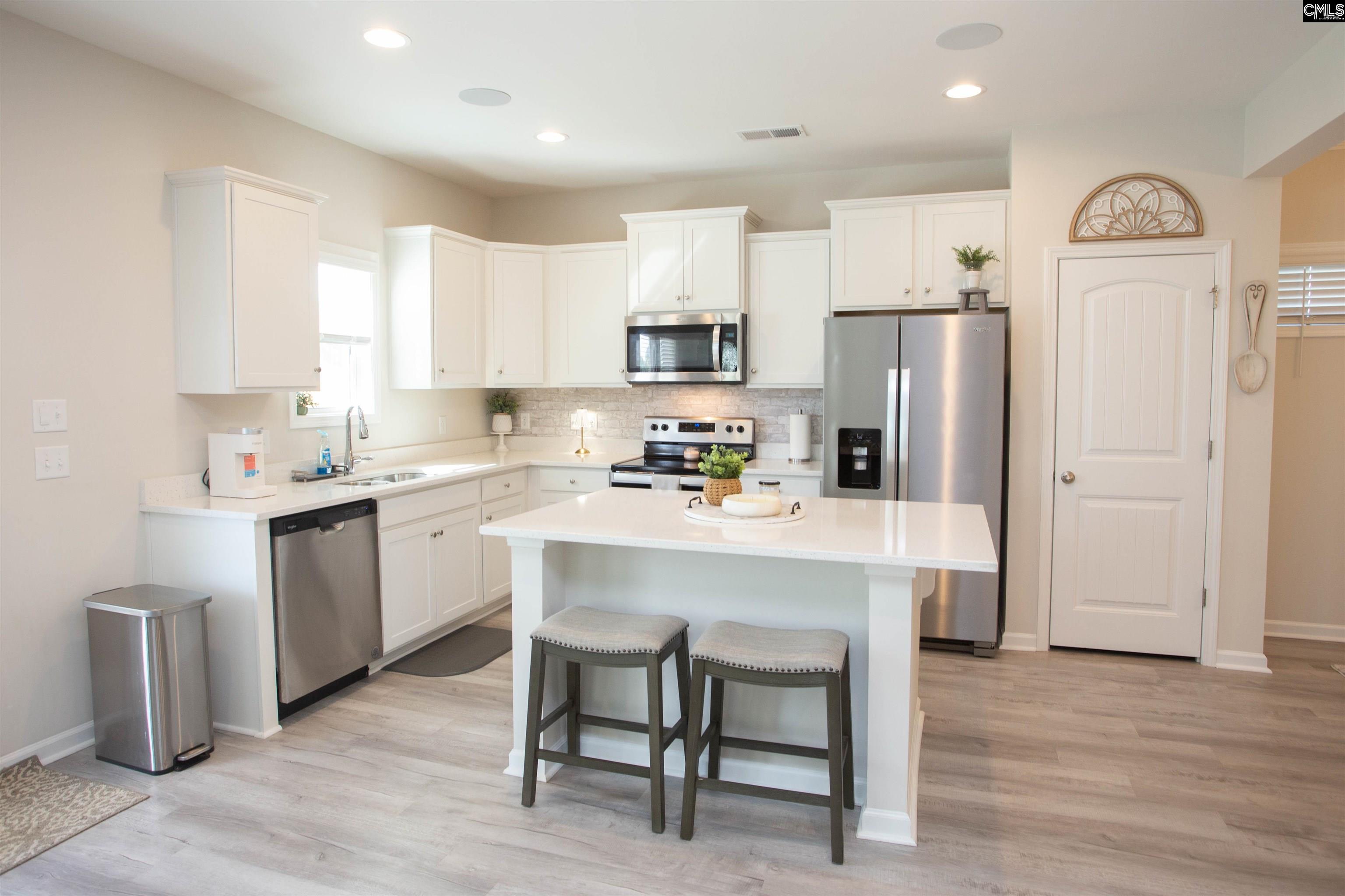272 Shadowbrook Way Camden, SC 29020 - Photo 9 of 43 a kitchen with a refrigerator a sink dishwasher a stove and white cabinets with wooden floor