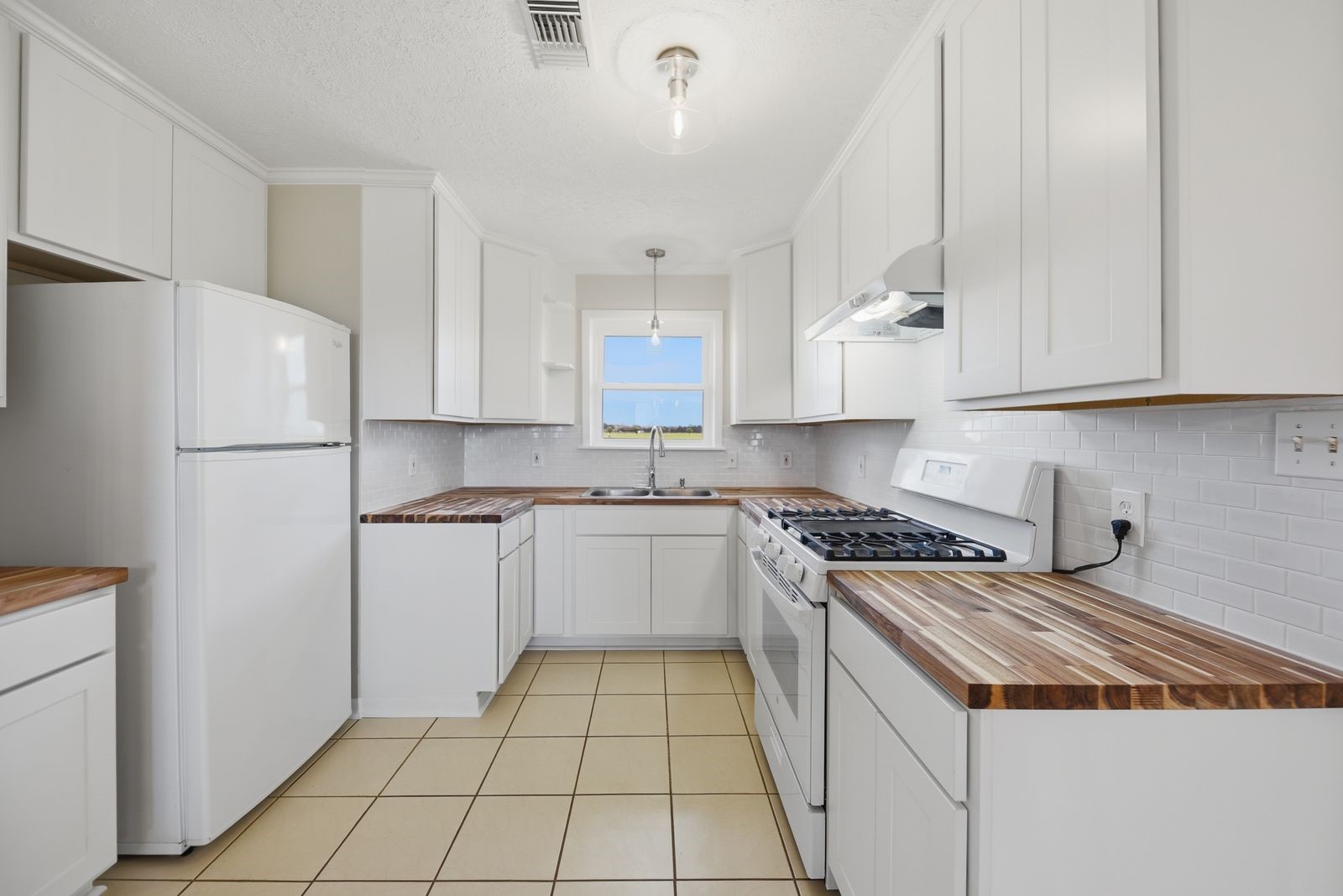 3249 Newsom Road Bellville, TX 77418 - Photo 6 of 20 a kitchen with a white cabinets and white appliances