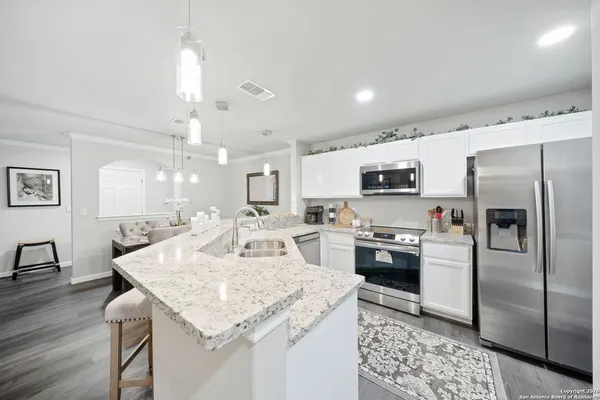 a kitchen with stainless steel appliances granite countertop a sink refrigerator and cabinets