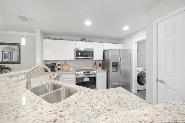 a kitchen with stainless steel appliances granite countertop a sink stove and refrigerator