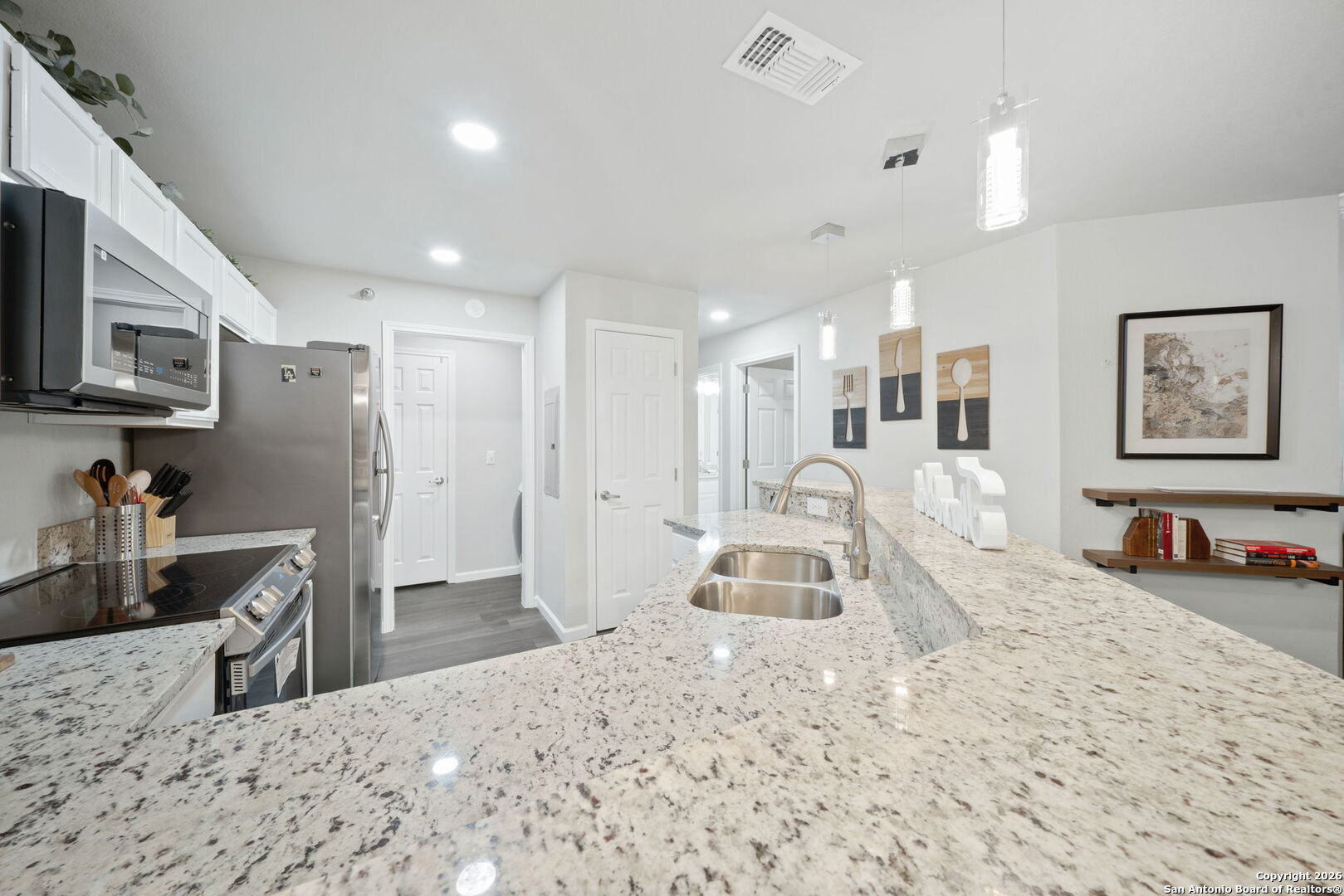 7323 Snowden Road, Unit 2201 San Antonio, TX 78229 - Photo 14 of 27 a kitchen with stainless steel appliances kitchen island granite countertop a sink refrigerator and microwave