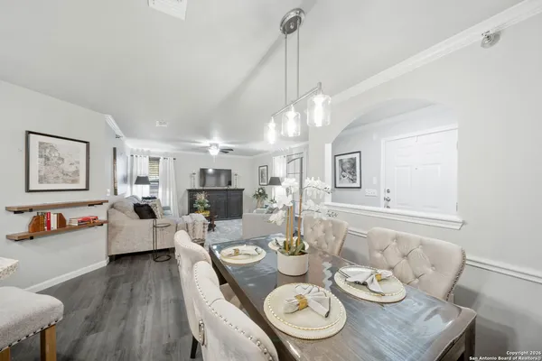 a living room with furniture kitchen view and a wooden floor
