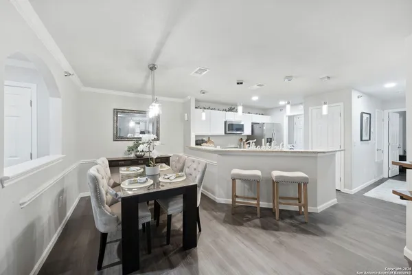 a dining area with a table chairs and a kitchen view
