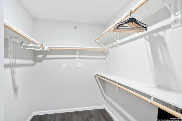 a view of walk in closet with empty racks