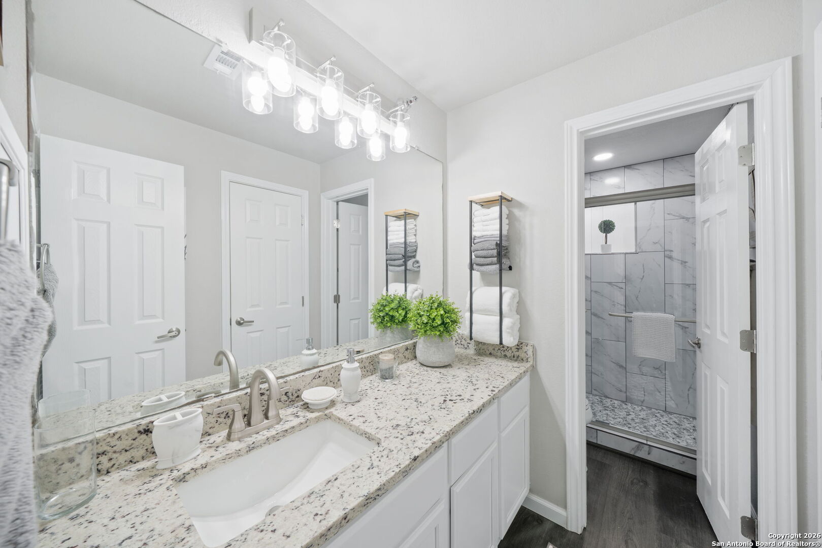 7323 Snowden Road, Unit 2201 San Antonio, TX 78229 - Photo 26 of 27 a bathroom with a granite countertop sink a mirror and a shower