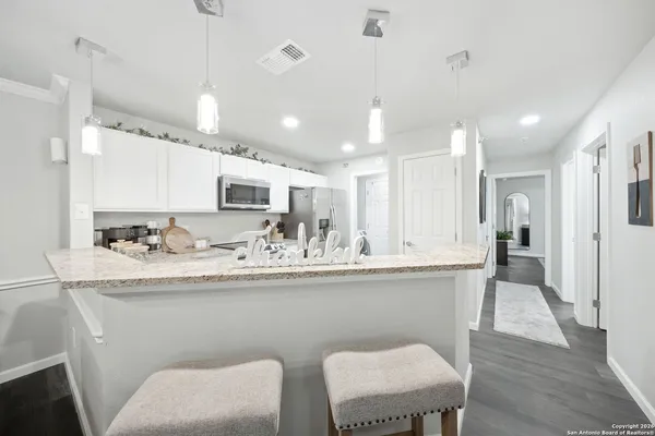 a kitchen with stainless steel appliances granite countertop a sink a stove a refrigerator with wooden floor