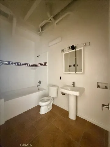 a large kitchen with a sink stainless steel appliances and cabinets