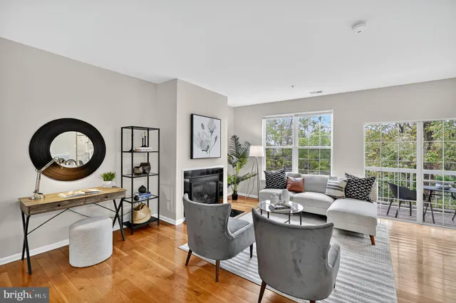 a living room with furniture a floor to ceiling window and a flat screen tv