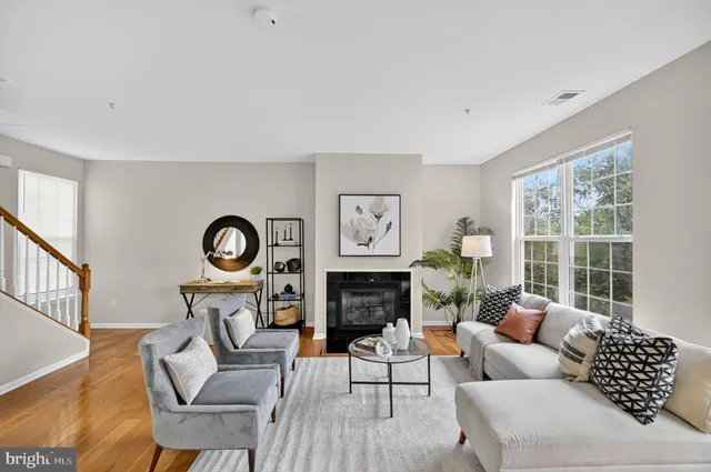 a living room with furniture a fireplace and a large window
