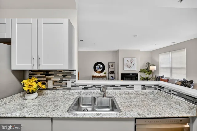 a kitchen with granite countertop a sink a stove and cabinets