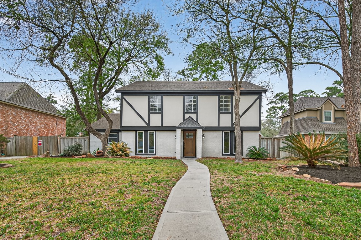 a view of a white house with a big yard and large tree
