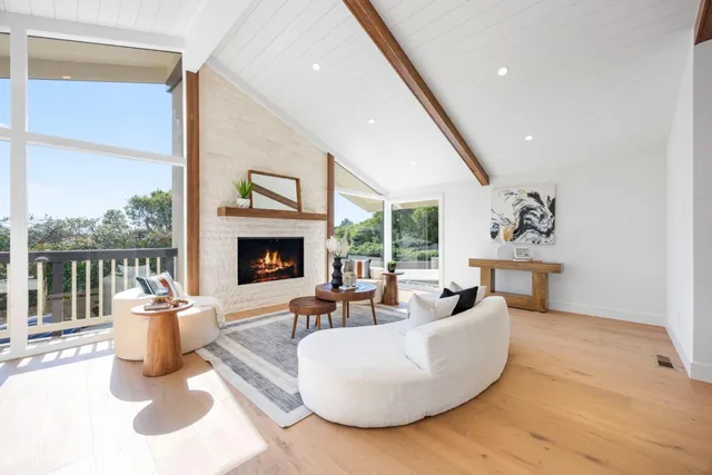 a living room with fireplace furniture and a large window