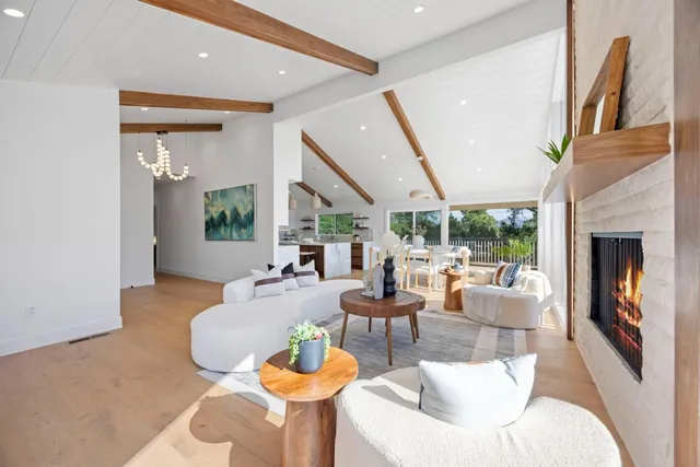 a living room with fireplace furniture and a large window