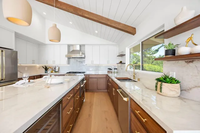 a kitchen with a stove a refrigerator and a sink with wooden floor