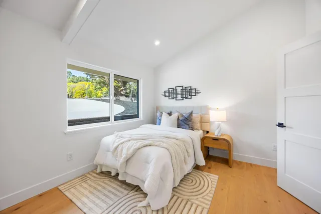 a bedroom with a bed and a large window