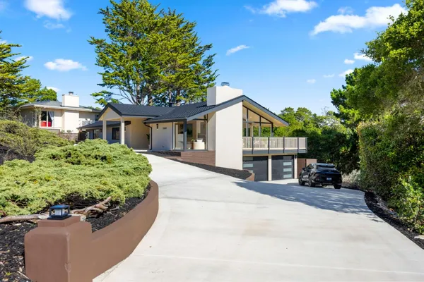 a front view of a house with a yard and potted plants
