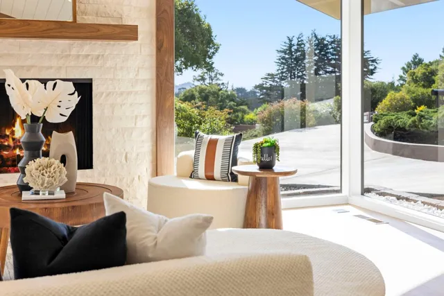a living room with fireplace furniture and a large window