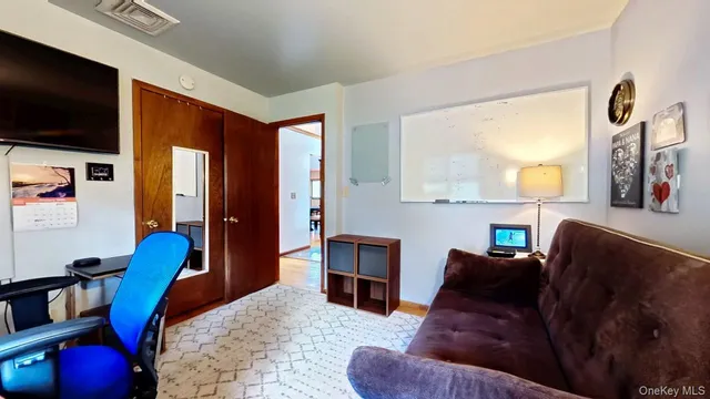 a living room with furniture a flat screen tv and kitchen view