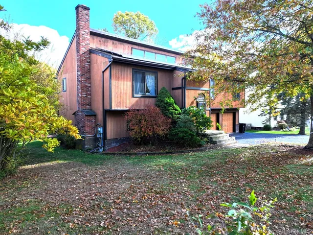 a view of a house with a yard and tree s