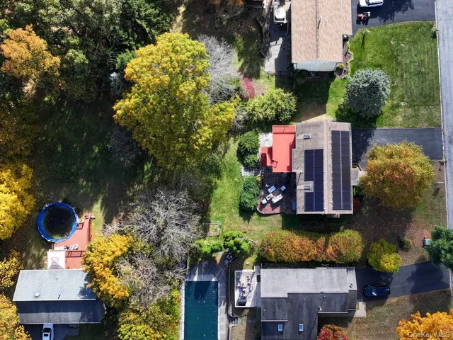 an aerial view of a house with a yard and large trees
