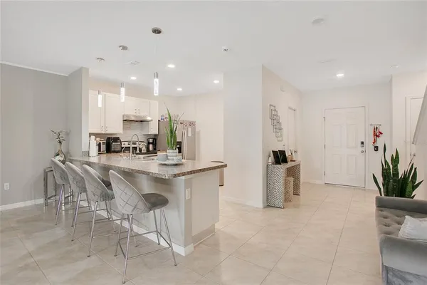 a kitchen with kitchen island a counter top space a sink stainless steel appliances and cabinets