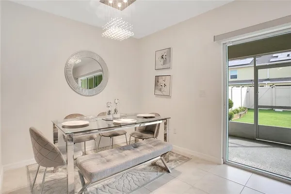 a dining room with furniture and a floor to ceiling window