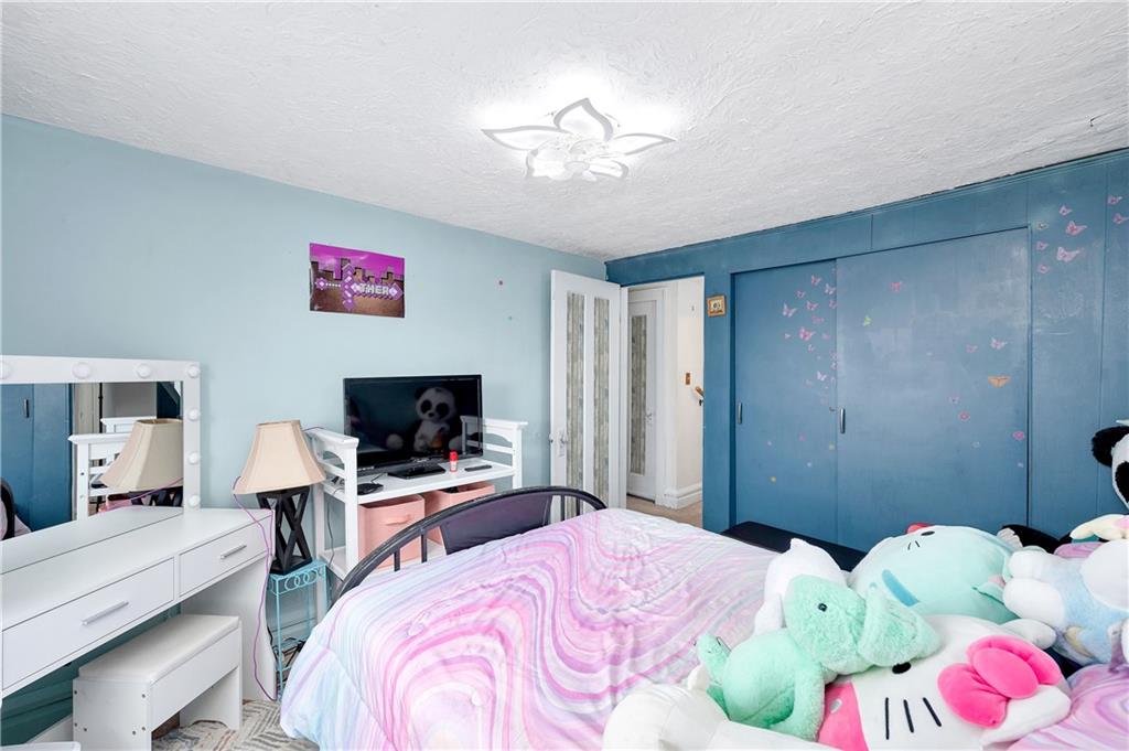 821 Vogan Street New Castle, PA 16101 - Photo 20 of 33 a bedroom with a bed and a flat screen tv